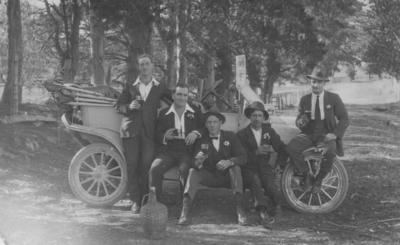 Five unidentified men seated on a car