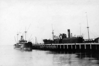 Two steamships tied up to a wharf